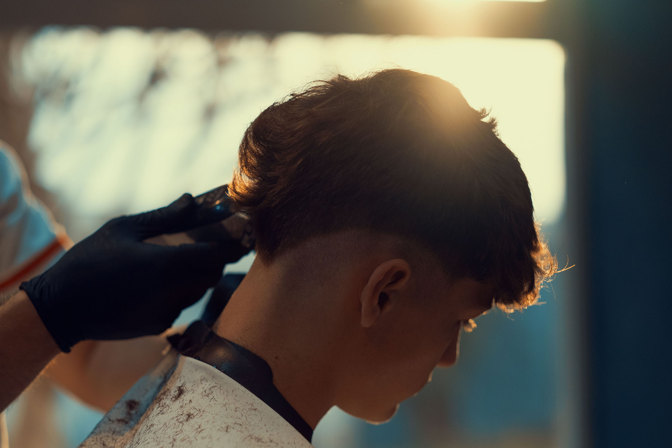 Barber grooming the hair of a boy in the barber shop undercut haarschnitt